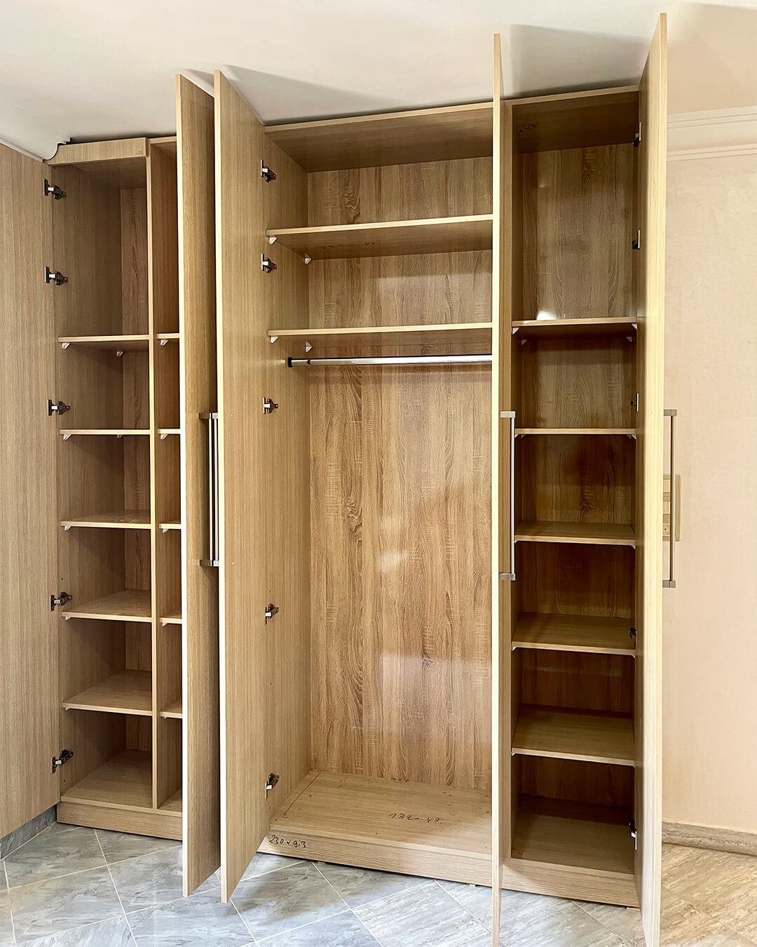 Armoire en MDF bois clair entièrement ouverte montrant étagères et penderie, fabrication sur mesure BOALUM