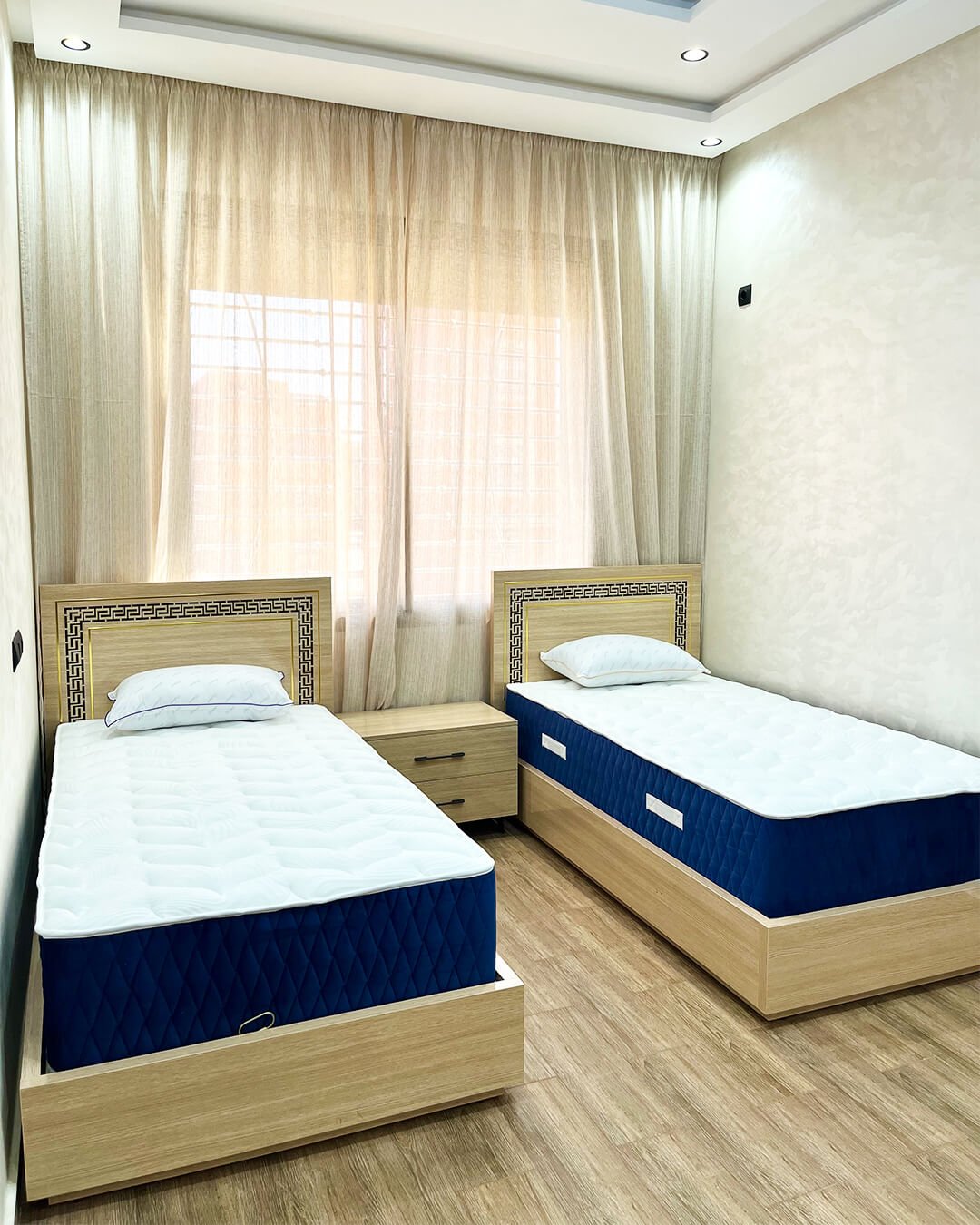 Chambre à coucher avec deux lits en MDF finition bois et table de chevet – BOALUM