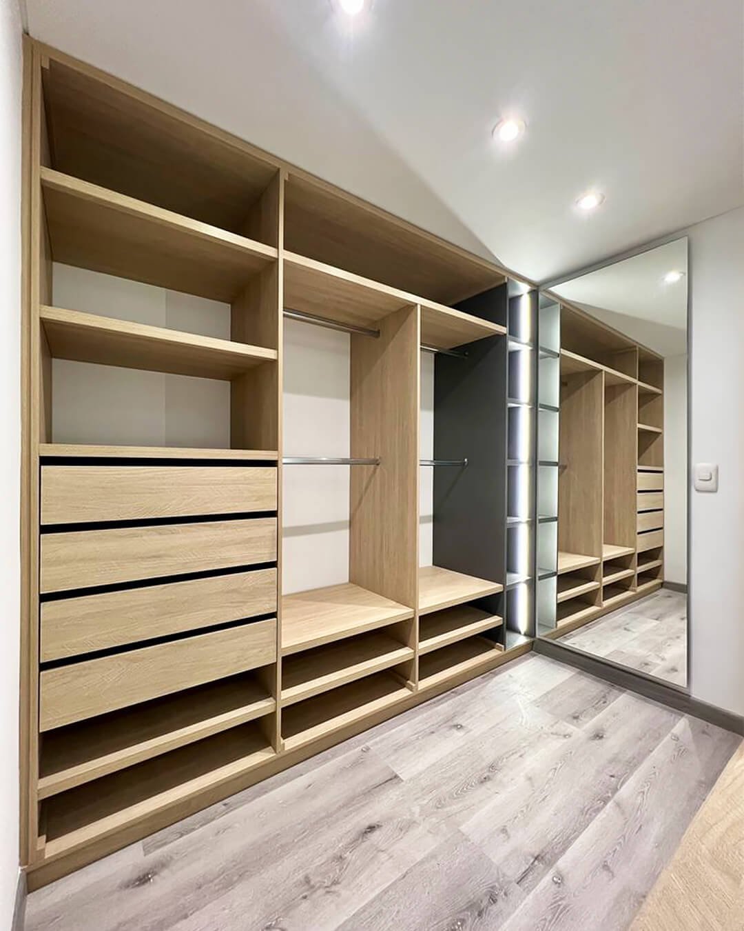 Placard dressing sur mesure en bois clair avec étagères et tiroirs modernes.