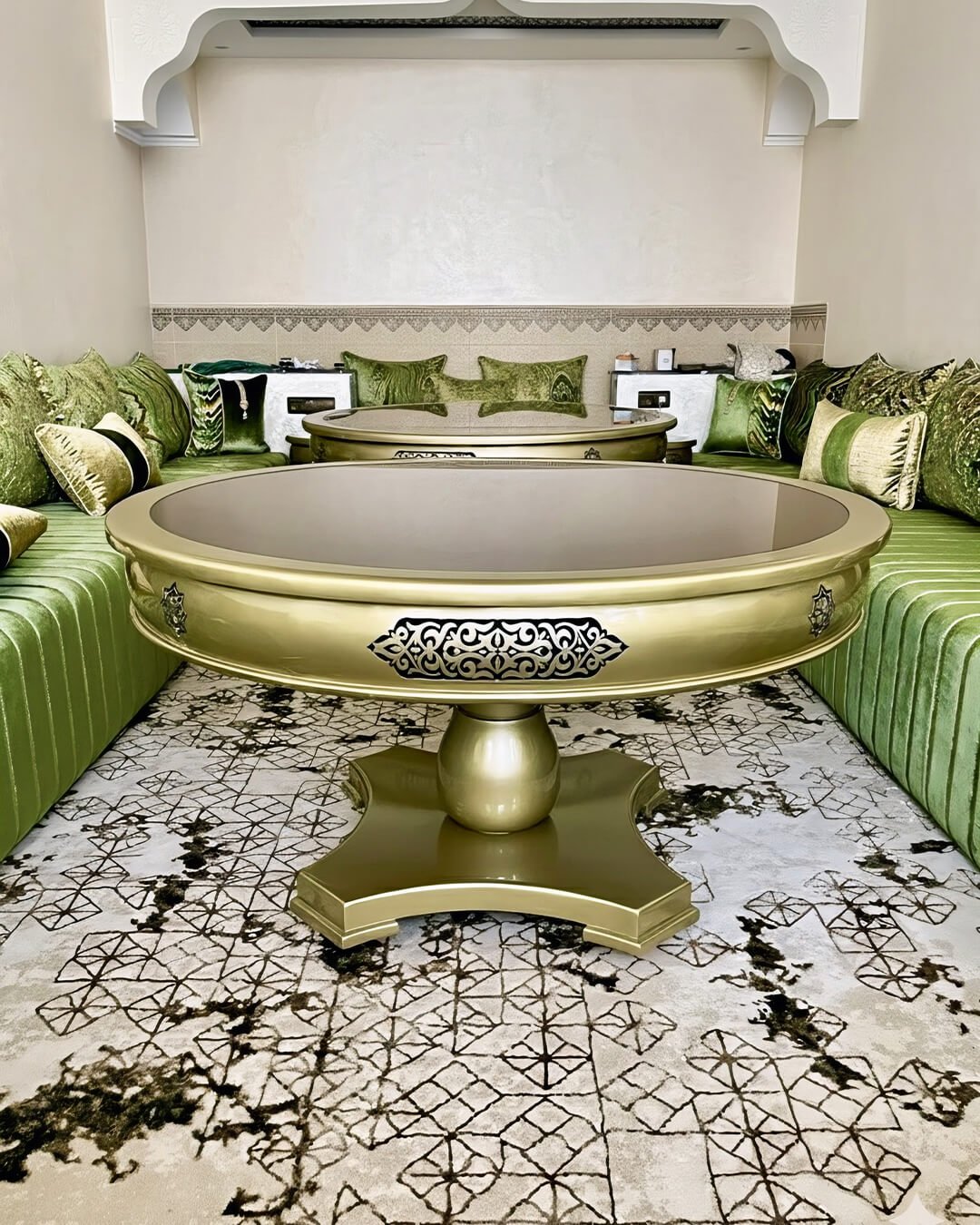 Table centrale marocaine dorée en bois sculpté avec plateau rond, idéale pour salon marocain traditionnel.
