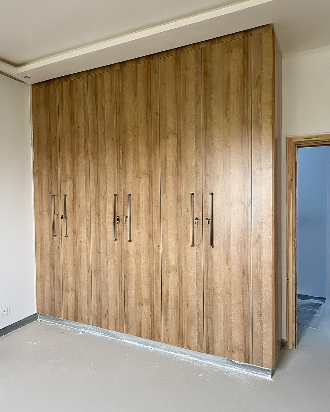 Placard sur mesure en MDF finition effet bois chêne avec poignées longues métalliques – fabrication BOALUM