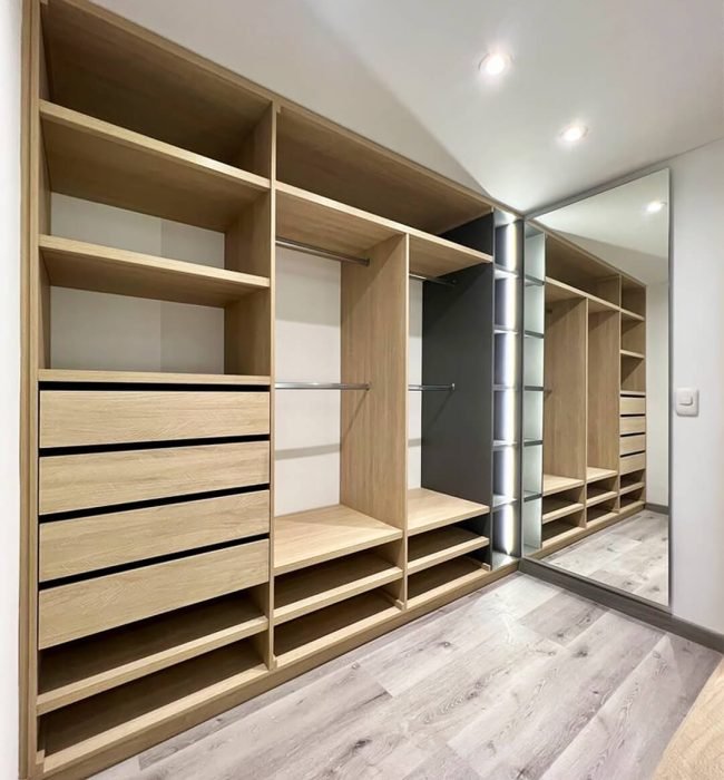 Placard dressing sur mesure en bois clair avec étagères et tiroirs modernes.